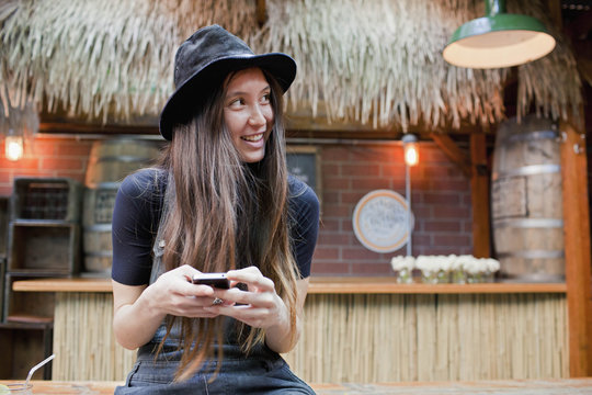 Smiling young woman using a smartphone 