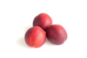 Three nectarine peaches on a white background