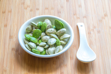 Parkia speciosa ( petai, bitter bean, twisted cluster bean, stinker or stink bean) with white cup and spoon