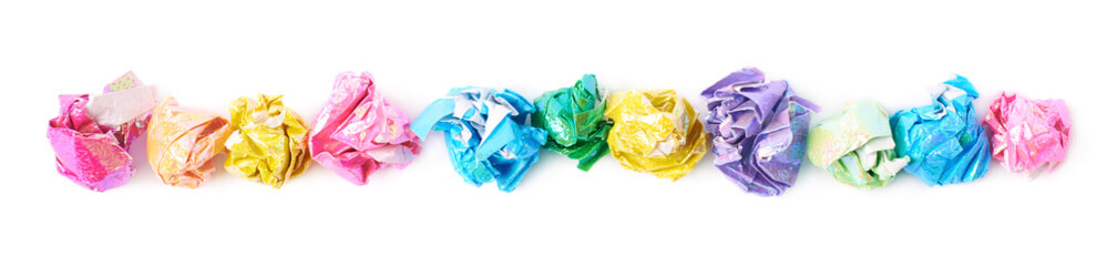 Line of colorful crumbled paper balls isolated
