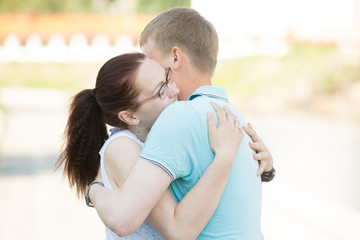 Beautiful young romantic couple in relationship meeting or parting on the street and hugging each...