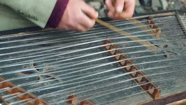 Old musical instrument. Cimbalom player play traditional folk music on string instrument. Closeup of traditional music instrument . Musician hands touch string on dulcimer. Acoustic folk sound