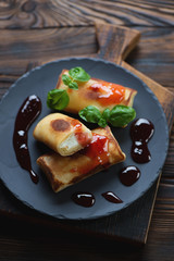 Rolled flapjacks stuffed with cottage cheese, selective focus