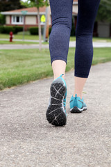 Runner/ woman  running on  a  road,  closeup on shoe/sneakers. .