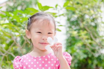 Cute little asian girl in garden on summer time