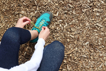 young woman runner tying shoelaces