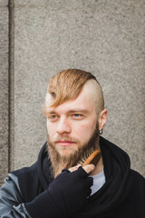 Stylish man brushing his beard