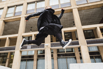 Stylish bearded man jumping in the street