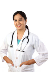 Happy young female doctor against white background