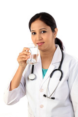 Happy young female doctor with a glass of water - 114892898