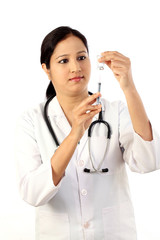 Young doctor woman with syringe against white background