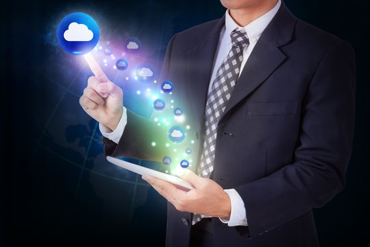 Businessman holding tablet with pressing cloud icon button. internet and technology concept