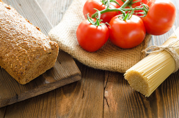 Baked bread with tomatos, and pasta on background