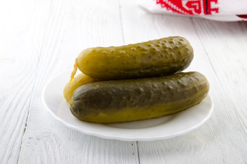 Pickled cucumber on a wooden white table. Russian style.