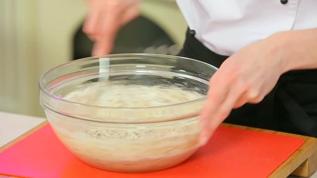 Cheff is making dough in a glass bowl