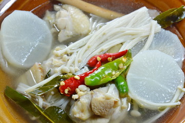 chicken leg with needle mushroom spicy and sour soup on bowl