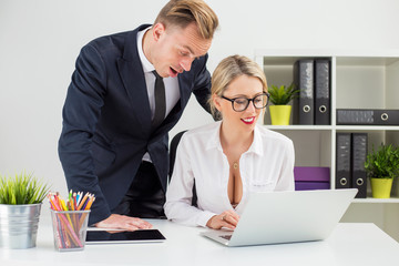 Boss leaning over his secretary