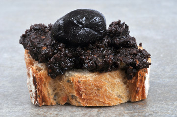 Tartine de tapenade avec une olive noire dessus