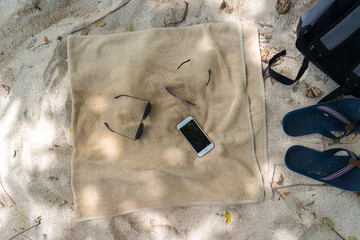 Flip flops, sunglasses, towel on the beach