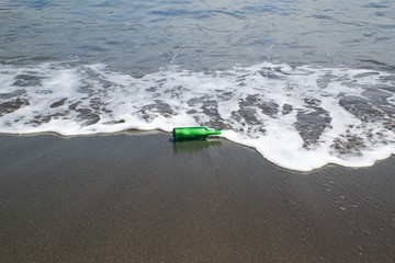 砂浜の緑の小瓶