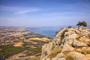 Fototapeta na wymiar Pastoral nature landscape of Arbel Cliff National park and Agriculture valley Magic view of Galilee Sea (Tiberius lake or Kineret) in the distance background. Seasons and travel. Low Galilee. Israel 