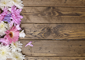 A page border made up of pink, purple and white flowers on a reclaimed wood background