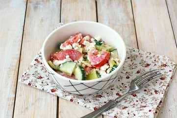 Healthy fresh salad from vegetable, tomatoes, cucumber, green pepper, cottage cheese, chives and olive oil