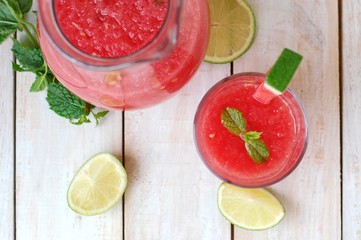 Healthy fresh smoothie drink from red watermelon, lime, mint and ice drift