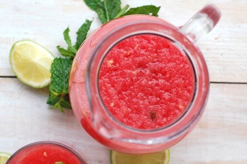 Healthy fresh smoothie drink from red watermelon, lime, mint and ice drift