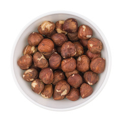 White ceramic cup bowl filled with the multiple hazelnuts isolat