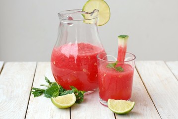 Healthy fresh smoothie drink from red watermelon, lime, mint and ice drift