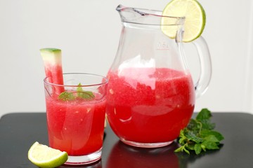 Healthy fresh smoothie drink from red watermelon, lime, mint and ice drift