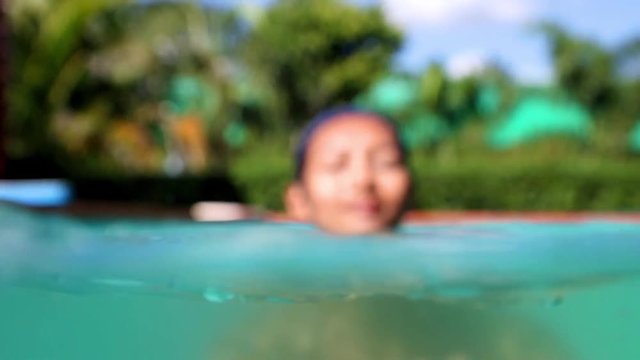 woman in a bathing cap swim in the swimming pool.
