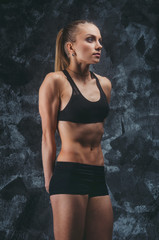 Fototapeta na wymiar Muscular female on gray background