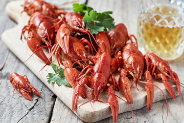 Red boiled crayfish on cutting board and a glass of beer.horizontal
