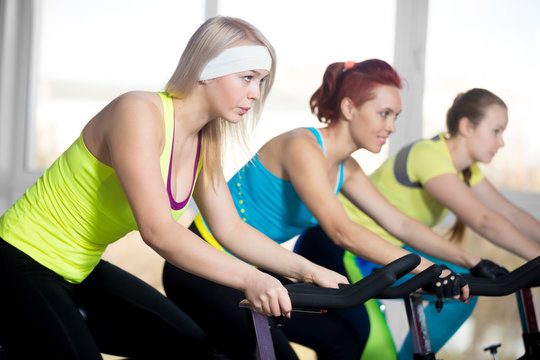 Group of cyclist women in fitness center