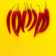 Red chili pepers on yellow. Top view, copy space - 114906687