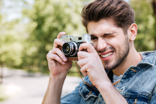 Close-up portrait of casual man making photo using camera