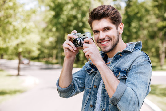 Happy casual man making photo on camera