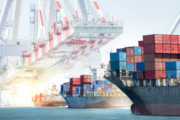 Container cargo ship entering the port with harbor crane background. Freight Transportation....