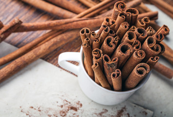 Cinnamon sticks on rustic wooden board with copy space top view