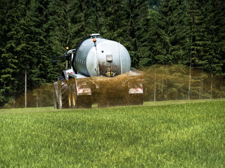 Bauer düngt ein Feld mit Gülle