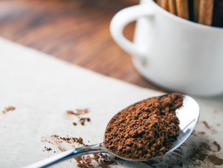 Cinnamon sticks and powder on rustic wooden board close up