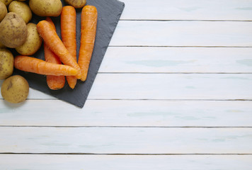 Assorted root vegetables on a painted table top background