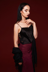Fototapeta premium Fashion studio shot of beautiful woman with makeup and hairstyle wearing evening dress