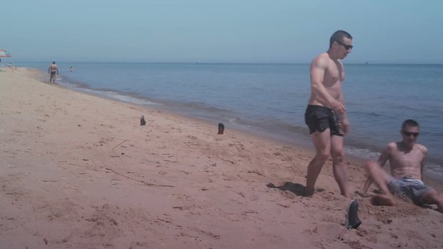 Two guys playing mini football on the beach at seaside