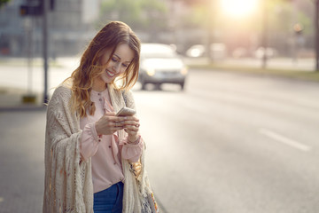 Junge Frau schreibt auf ihrem Mobiltelefon