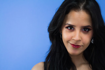 Woman looking into the camera on a blue background