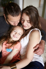 Lovely family hugging together at home