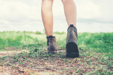 Young adventure woman feet walking on gravel in the countryside.